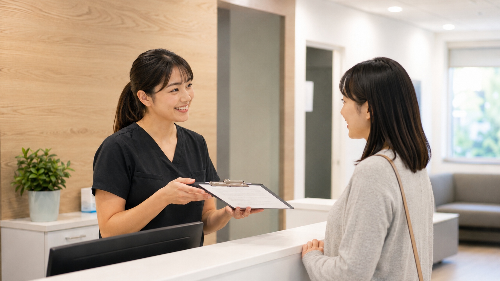 クリニックの受付スタッフが労災診療の手続きを説明している様子