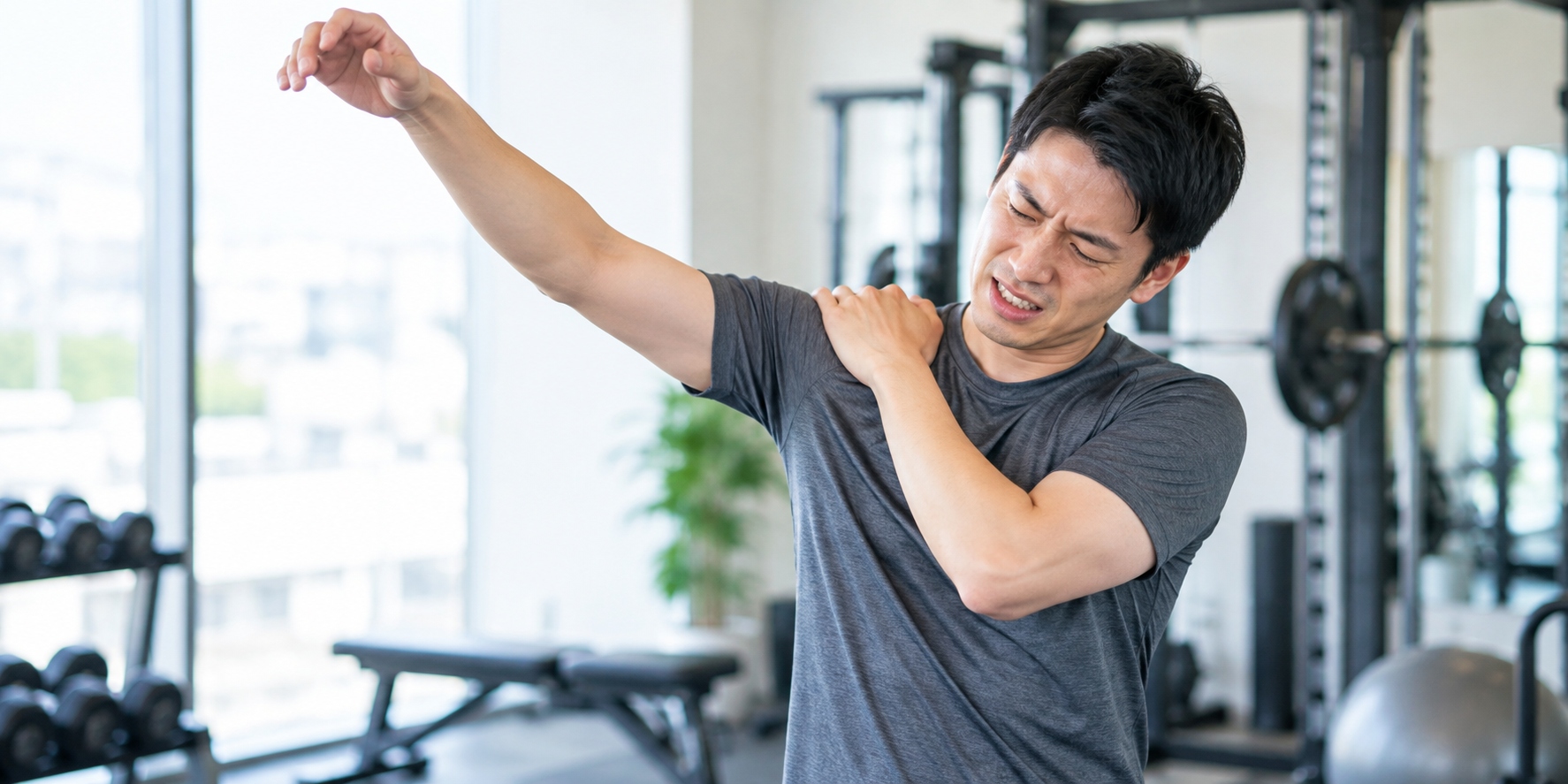 トレーニング中に肩の痛みを感じる男性