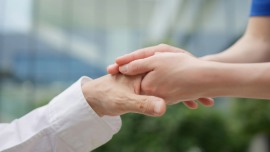 不安な患者さんに寄り添う医療スタッフの手